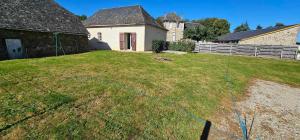a yard with a fence and a house at Maison de village in Sadroc