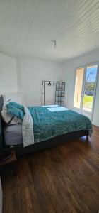 a bedroom with a bed in a room with wooden floors at Maison de village in Sadroc