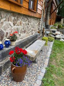 een bank en bloemen voor een stenen huis bij Chaloupka Království in Šluknov