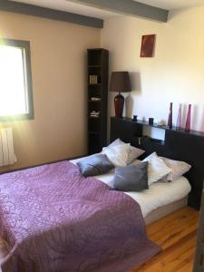 a bedroom with two beds with purple blankets and pillows at Chambre chez l'habitant in Châteauvieux