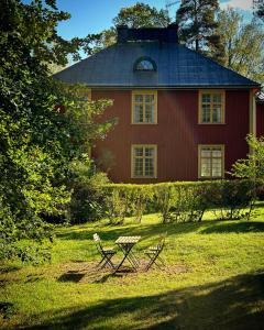 a red house with a picnic table in front of it at Officersvillorna, Älvkarleby Vandrarhem in Älvkarleby