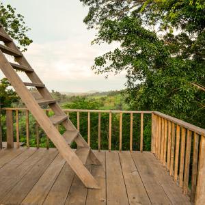 un porche de madera con una escalera en la cubierta en Rumhaoy Maison en Phumĭ Pu Pal
