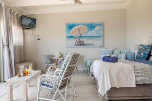 a bedroom with a bed and a table and chairs at Forever Blue in St. Helena Bay