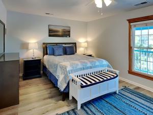 - une chambre avec un lit doté d'une couette bleue et d'une fenêtre dans l'établissement Saltcreek Sunsets, à Tybee Island