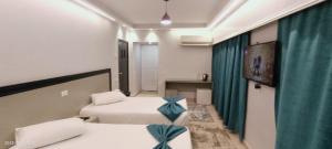 ein Zimmer mit 2 Betten und einem Sofa in einem Zimmer in der Unterkunft Salma Hotel Cairo in Kairo