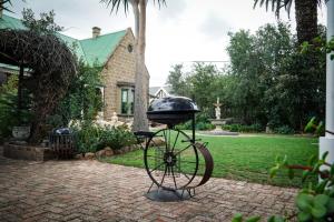 a grill on a bike on a brick yard at Outentique Accommodation in Oudtshoorn