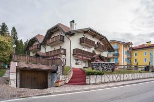 un edificio al lado de una calle con un cartel en Giongo Residence Aparthotel 201, en Lavarone