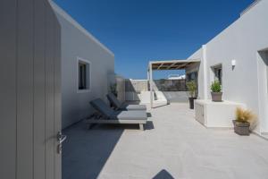 New Sea Serenity Villas Next to the Sea With Private Jacuzzi في Vlychada: فناء مع كراسي للاستلقاء في مبنى أبيض
