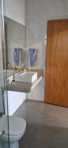 グアペにあるCasa Guapeのバスルーム(洗面台、トイレ付)、木製のドアが備わります。