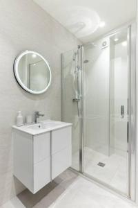 y baño blanco con lavabo y ducha. en Trocadéro/Victor Hugo : Luxury Apartment 1BR-4P, en París