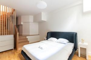 1 dormitorio con 1 cama grande y cabecero negro en Trocadéro/Victor Hugo : Luxury Apartment 1BR-4P, en París