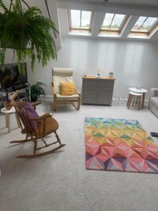 a living room with a chair and a colorful rug at Stylish apartment in the centre of Hebden Bridge. in Hebden Bridge