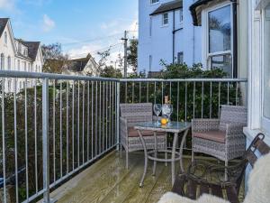 um pátio com uma mesa e cadeiras numa varanda em Caerleon em Salcombe
