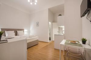 a white apartment with a bed and a dining table at Klauzál Garden City Apartments- studio K32 in Budapest
