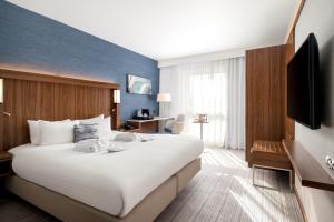 a hotel room with a large bed and a television at Courtyard by Marriott Glasgow Airport in Paisley