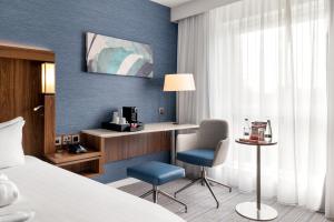 a hotel room with a bed and a desk and chair at Courtyard by Marriott Glasgow Airport in Paisley