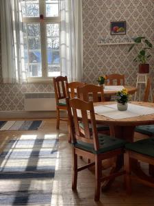 comedor con mesa de madera y sillas en Officersvillorna, Älvkarleby Vandrarhem, en Älvkarleby