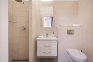een witte badkamer met een toilet en een wastafel bij Klauzál Garden City Apartments- Studio K31 in Boedapest