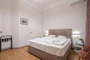 een slaapkamer met een groot bed met witte lakens bij Klauzál Garden City Apartments- Studio K31 in Boedapest