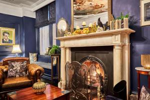 a living room with a fireplace and a chair and a table at The Lawrence in Derry Londonderry
