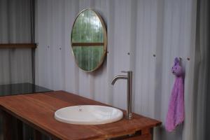 W łazience znajduje się umywalka i lustro. w obiekcie Rumhaoy Maison w mieście Phumĭ Pu Pal