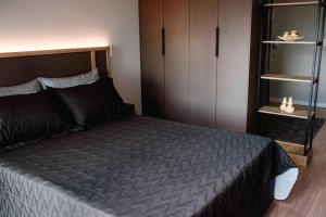 una camera con un grande letto e un armadio di Loft divino no Parque Una a Pelotas