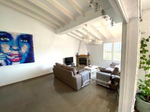 a living room with couches and a painting on the wall at Casa David in Teulada +7 photos