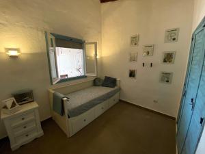 a small bedroom with a bed and a window at Casa David in Teulada