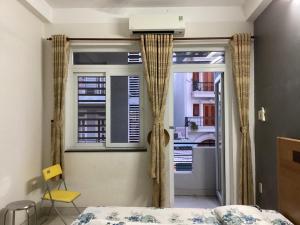 um quarto com uma cama e uma janela em KEIRA s HOUSE em Ho Chi Minh