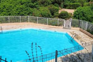 uma grande piscina azul ao lado de uma cerca em Joli T2, terrasse, vue Mer pour 4 personnes em Sainte-Maxime