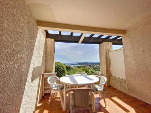 d'une table et de chaises sur un balcon avec une fenêtre. dans l'établissement Joli T2, terrasse, vue Mer pour 4 personnes, à Sainte-Maxime