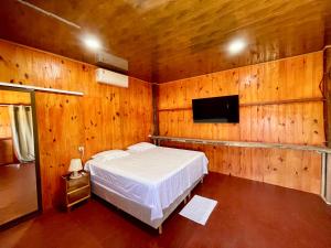 um quarto com uma cama e uma televisão de ecrã plano em Delta Chalé em Tutóia