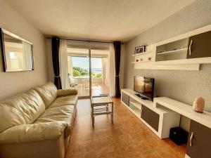 uma sala de estar com um sofá e uma televisão em Joli T2, terrasse, vue Mer pour 4 personnes em Sainte-Maxime