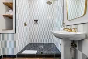 Gruene River Inn في نيو بروانفيلز: حمام مع حوض ومرآة