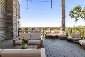 een patio met banken en stoelen op een houten terras bij Gruene River Inn in New Braunfels