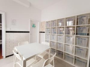 a white table and chairs in a room with shelves at Daydream Medano Coliving in El Médano