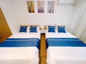 two beds in a room with blue and white at サクラシャドウ　スカイツリー in Tokyo