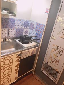 a small kitchen with a sink and a stove at 美ハウス in Tokyo