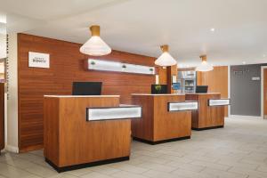 a lobby of a hotel with wooden desks and pendant lights at Courtyard by Marriott Glasgow Airport in Paisley