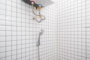 ジョグジャカルタにあるUrbanview Griya Kusumo Seturan Yogyakartaの白いタイル張りのバスルーム(シャワー付) +71枚の写真