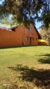 una casa arancione con un ampio giardino con un albero di Casa quinta con pileta a Santa Rosa