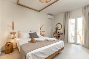 una camera da letto con un letto con un cappello sopra di Heavenly Suites & Studios a Naxos Chora