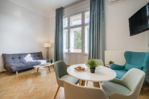 - un salon avec une table, des chaises et un canapé dans l'établissement Klauzál Garden City Apartments - deluxe studio with Balcony K23, à Budapest