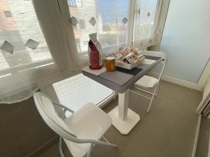 a small table and chairs in a room with a window at IRIS ROOM in Monopoli