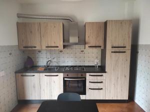 uma cozinha com armários de madeira e um fogão em A Casa di Francesca em Lucca
