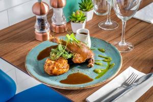 a blue plate of food with a chicken on a table at Courtyard by Marriott Glasgow Airport in Paisley