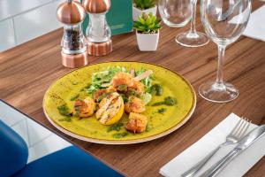 a plate of food with shrimp and vegetables on a table at Courtyard by Marriott Glasgow Airport in Paisley