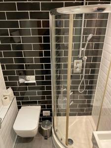 a bathroom with a shower with a toilet and a sink at City Continental London Kensington in London