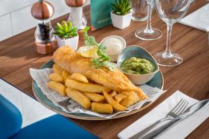 a plate of fish and french fries on a table at Courtyard by Marriott Glasgow Airport in Paisley