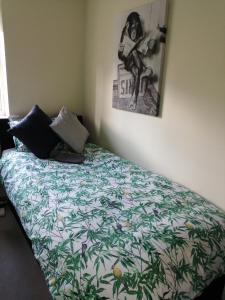 a bedroom with a bed with a green and white comforter at 59 Halstead - Gorgeous single bedroom with private bathroom in Halstead